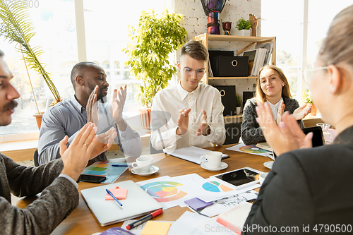 Image of Group of young business professionals having a meeting, creative office