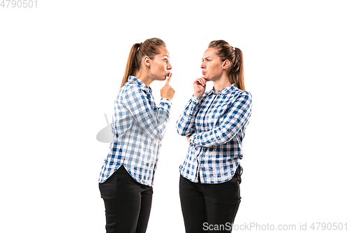 Image of Young handsome woman arguing with herself on white studio background.