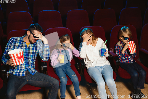 Image of Young caucasian family watching a film at a movie theater