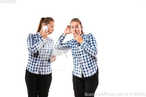 Image of Young handsome woman arguing with herself on white studio background.