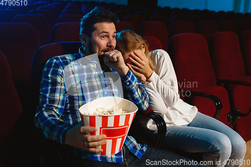 Image of Attractive young caucasian couple watching a film at a movie theater