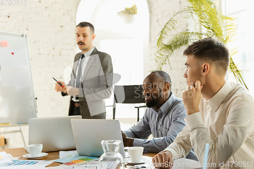Image of Group of young business professionals having a meeting, creative office