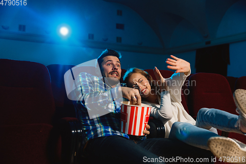 Image of Attractive young caucasian couple watching a film at a movie theater