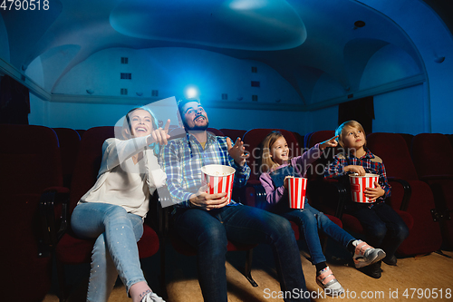 Image of Young caucasian family watching a film at a movie theater