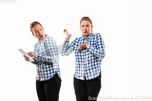 Image of Young handsome woman arguing with herself on white studio background.