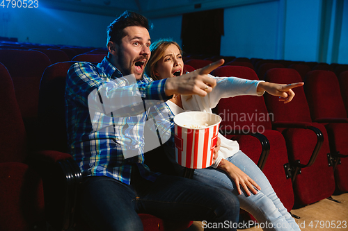 Image of Attractive young caucasian couple watching a film at a movie theater