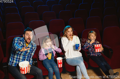 Image of Young caucasian family watching a film at a movie theater