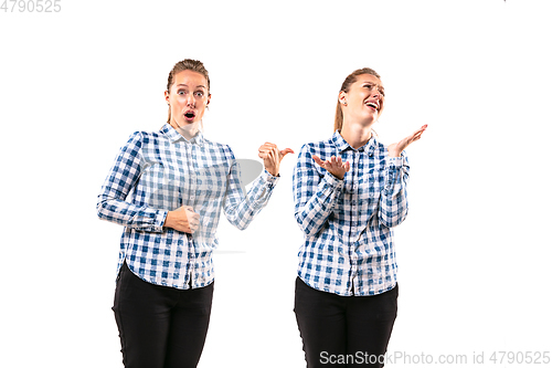 Image of Young handsome woman arguing with herself on white studio background.