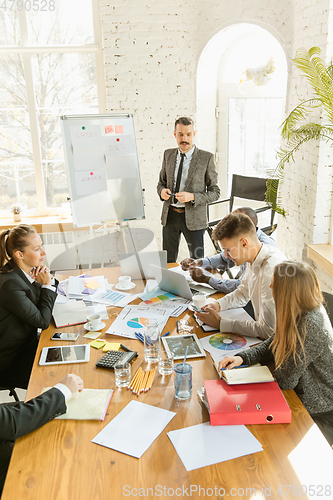 Image of Group of young business professionals having a meeting, creative office
