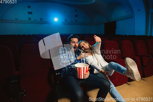 Image of Attractive young caucasian couple watching a film at a movie theater