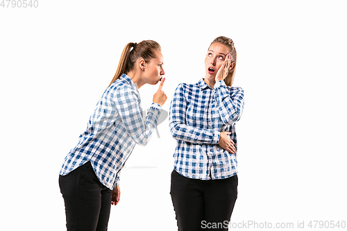 Image of Young handsome woman arguing with herself on white studio background.