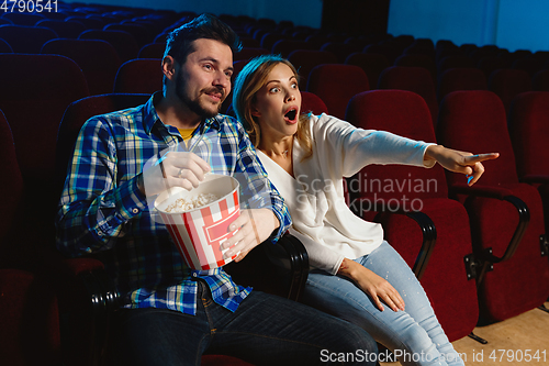 Image of Attractive young caucasian couple watching a film at a movie theater