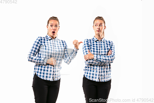 Image of Young handsome woman arguing with herself on white studio background.