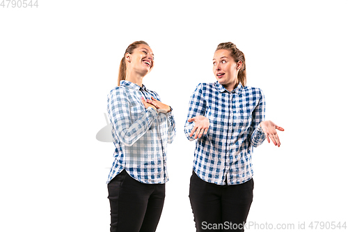 Image of Young handsome woman arguing with herself on white studio background.