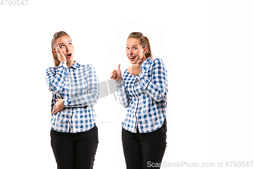 Image of Young handsome woman arguing with herself on white studio background.