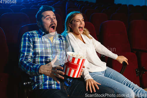 Image of Attractive young caucasian couple watching a film at a movie theater