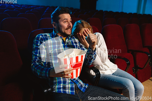 Image of Attractive young caucasian couple watching a film at a movie theater