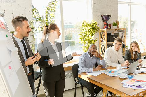 Image of Group of young business professionals having a meeting, creative office