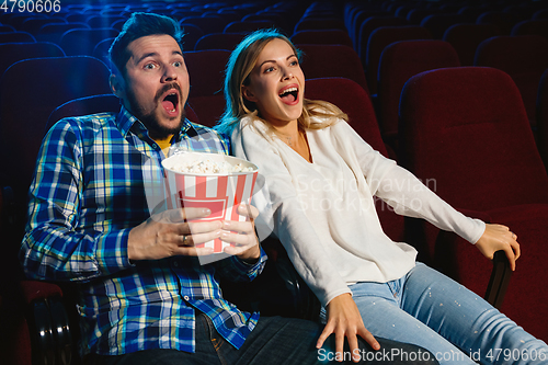 Image of Attractive young caucasian couple watching a film at a movie theater