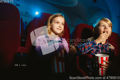 Image of Little girl and boy watching a film at a movie theater