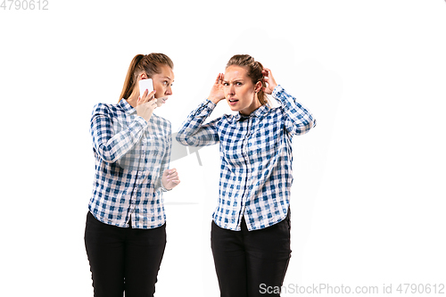 Image of Young handsome woman arguing with herself on white studio background.