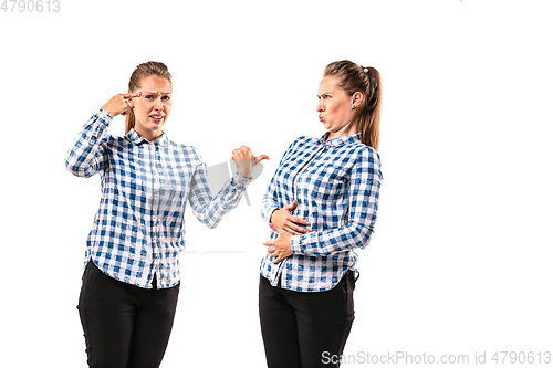 Image of Young handsome woman arguing with herself on white studio background.