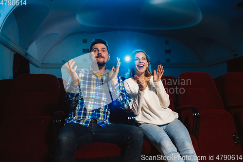 Image of Attractive young caucasian couple watching a film at a movie theater