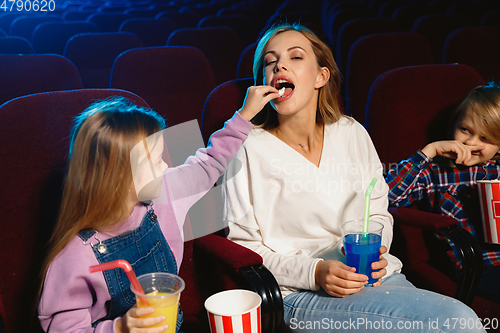 Image of Young caucasian family watching a film at a movie theater