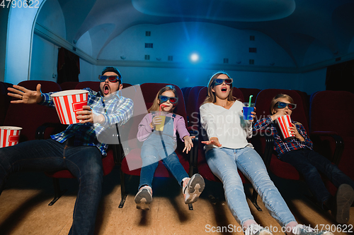 Image of Young caucasian family watching a film at a movie theater