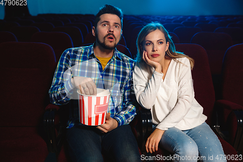 Image of Attractive young caucasian couple watching a film at a movie theater