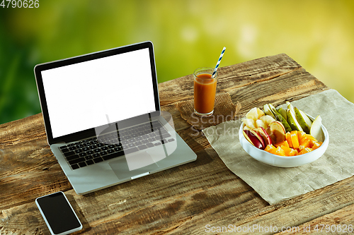 Image of Blank laptop on a wooden table outdoors, mock up