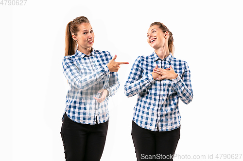 Image of Young handsome woman arguing with herself on white studio background.