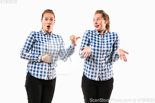 Image of Young handsome woman arguing with herself on white studio background.