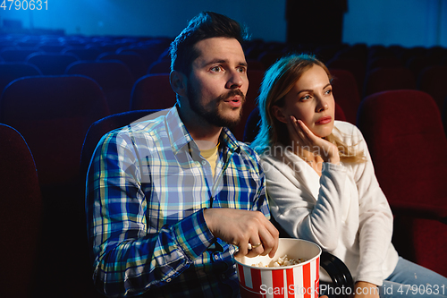 Image of Attractive young caucasian couple watching a film at a movie theater