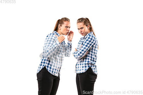 Image of Young handsome woman arguing with herself on white studio background.