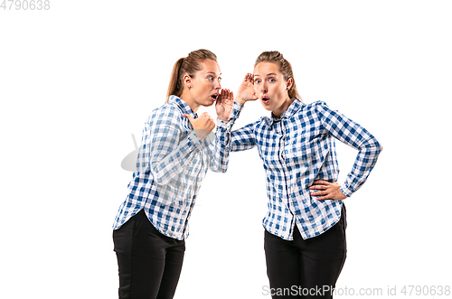 Image of Young handsome woman arguing with herself on white studio background.