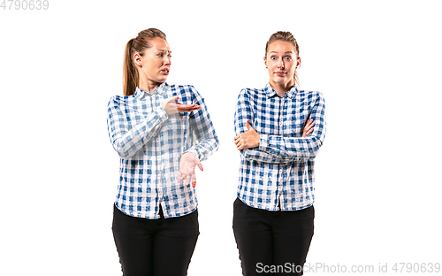 Image of Young handsome woman arguing with herself on white studio background.