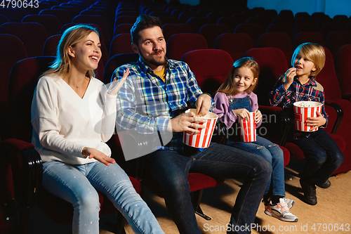 Image of Young caucasian family watching a film at a movie theater