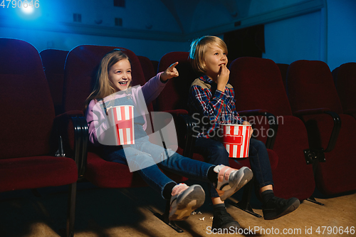 Image of Little girl and boy watching a film at a movie theater