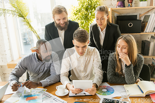 Image of Group of young business professionals having a meeting, creative office