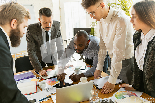 Image of Group of young business professionals having a meeting, creative office