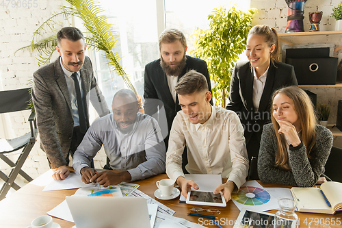 Image of Group of young business professionals having a meeting, creative office