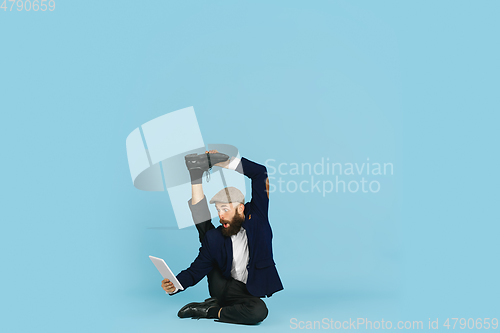 Image of Businessman having fun dancing break dance on blue background at work