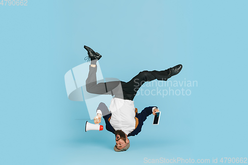 Image of Businessman having fun dancing break dance on blue background at work