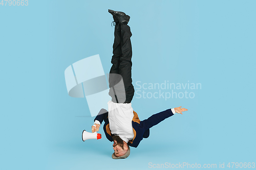 Image of Businessman having fun dancing break dance on blue background at work