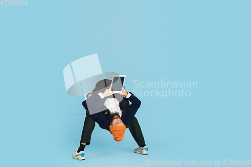 Image of Businessman having fun dancing break dance on blue background at work