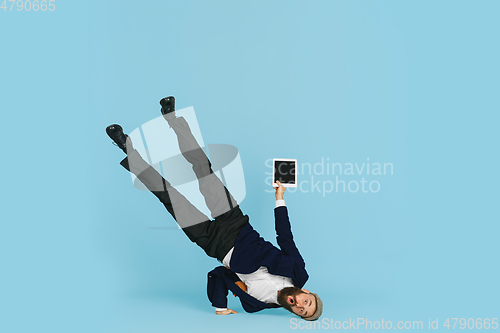 Image of Businessman having fun dancing break dance on blue background at work