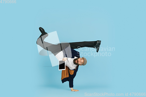 Image of Businessman having fun dancing break dance on blue background at work