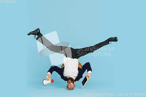 Image of Businessman having fun dancing break dance on blue background at work