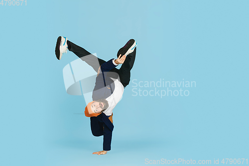 Image of Businessman having fun dancing break dance on blue background at work